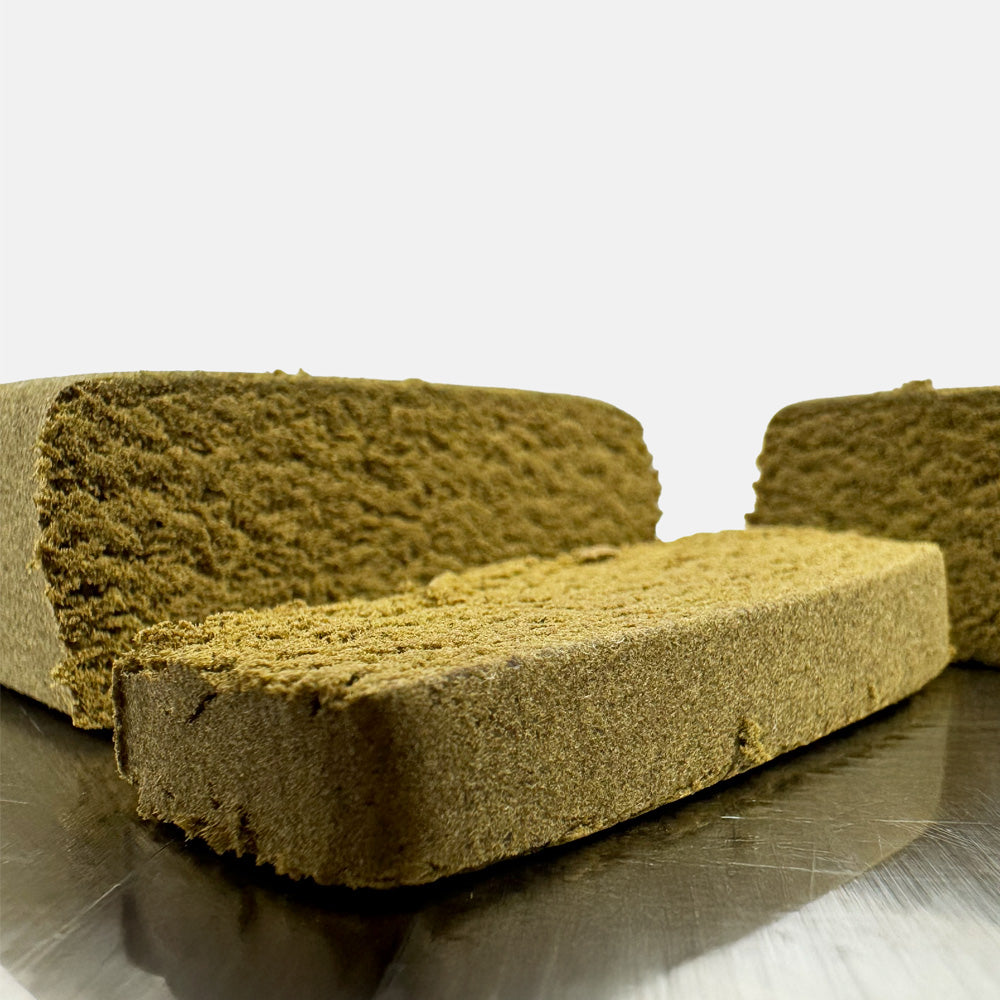 Zvětšený detail kousku CBD Dry Sift Cherry Pie rozříznutého na polovinu